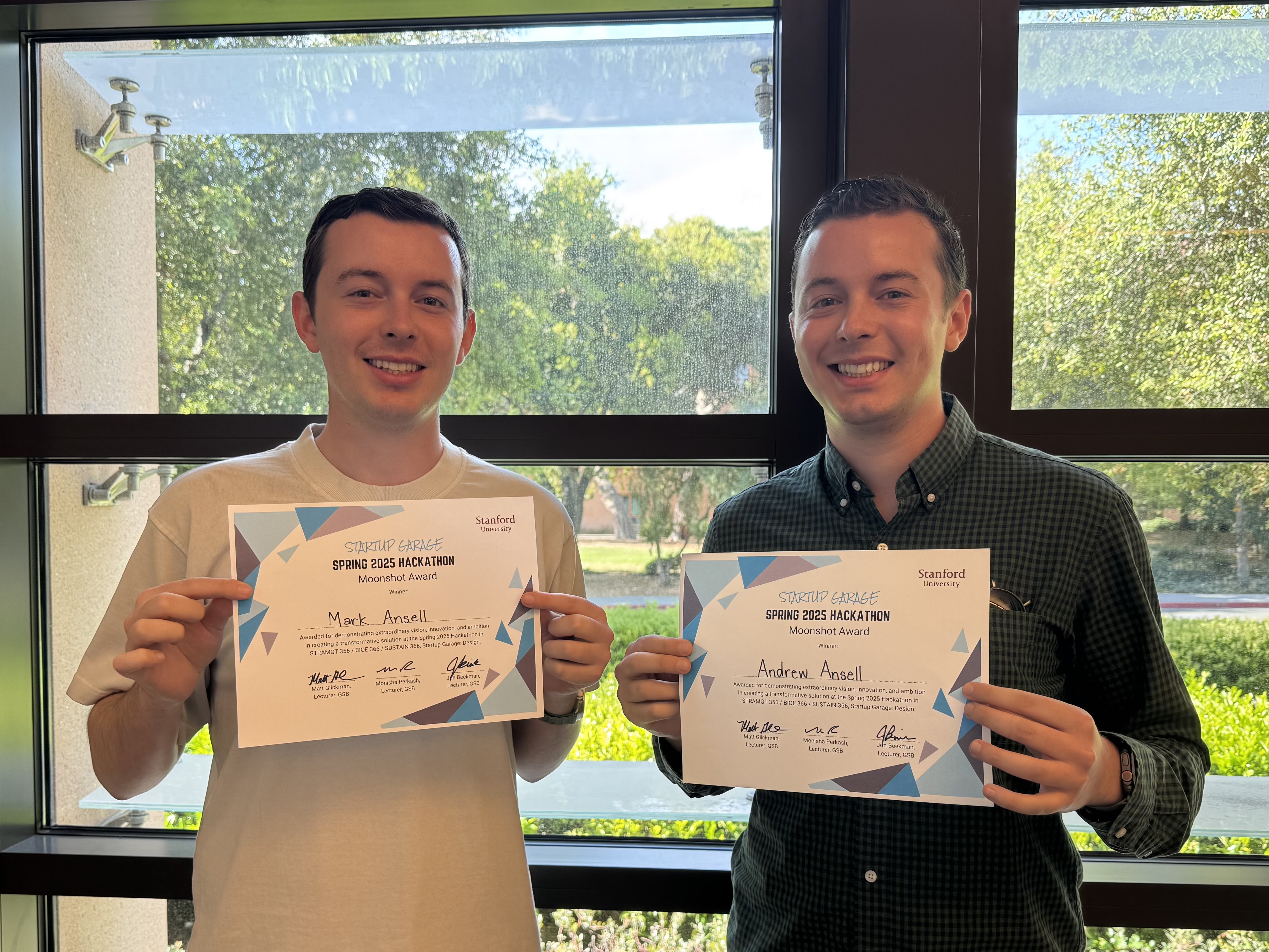 Mark and Andrew holding Moonshot Award certificates